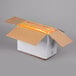 A white cardboard box with orange tape and a yellow package of LouAna Coconut Oil inside.
