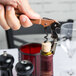 A person using a Pulltap's Original copper corkscrew to open a bottle of wine.