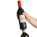 A hand using a Franmara electric corkscrew to open a bottle of wine.