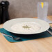 A Thunder Group ivory melamine pasta bowl filled with soup on a table.