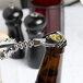 A person using a Franmara Tavern Wing Corkscrew to open a bottle of beer.
