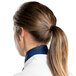 A woman with a ponytail wearing a navy blue Intedge chef neckerchief.