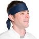 A man wearing a navy blue Intedge chef neckerchief on his head.