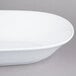 An American Metalcraft white melamine serving bowl with a white rim on a gray surface.