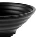 A close-up of a black GET Nara melamine bowl with a black rim.