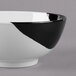 A close up of a white melamine bowl with a black and white interior.