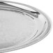 A Vollrath stainless steel round serving tray with intricate designs.