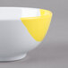 A close-up of a white GET melamine bowl with yellow paint on it.