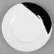 A close-up of a GET Bold white melamine plate with a black and white wide rim.