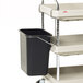A Metro utility cart with a black wastebasket and metal holder.