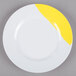 A white plate with a wide yellow rim.