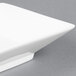 A white square porcelain bowl on top of a white square plate.