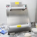 A Doyon countertop dough sheeter with a roll of dough on it.