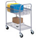 A Safco metallic gray wire mail cart with file folders and boxes on it.