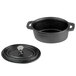 An American Metalcraft pre-seasoned black cast iron oval Dutch oven with a lid on a kitchen counter.