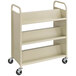 A beige metal Safco book cart with six shelves and black wheels.
