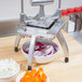 A Nemco vegetable cutter with a bowl of sliced red onions and orange peppers.