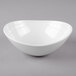 A white oval bowl with a textured rim on a white surface.