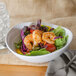 A Magnolia melamine oval bowl filled with salad with shrimp and vegetables.