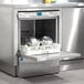 A Hobart undercounter dishwasher with a shelf open and dishes inside.