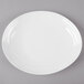 A white oval melamine platter with a textured rim on a gray surface.