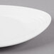 A close-up of a GET Magnolia ivory melamine oval platter with a textured rim.