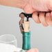 A person using a Franmara Duo-Lever corkscrew to open a bottle of wine.