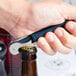 A hand holding a Pulltap's Original Waiter's Corkscrew with a dark blue handle opening a bottle.