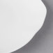 A close-up of a Villeroy & Boch white bone porcelain flat plate with a curved edge.