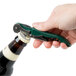 A hand using a Franmara Duo-Lever corkscrew with a green enamel handle to open a bottle.