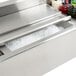 A stainless steel Eagle Group underbar ice bin filled with ice and drinks on a counter.