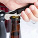 A hand using a Pulltap's Original Waiter's Corkscrew to open a brown bottle.