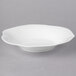 A white Villeroy & Boch bone porcelain bowl with a large rim on a gray surface.