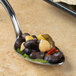 A Bon Chef soup/dessert spoon filled with black beans and corn.