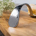 A Bon Chef silver spoon on a wood surface.