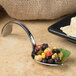 A Bon Chef Reflections spoon filled with black beans and corn.