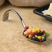 A Bon Chef stainless steel spoon full of food on a table.