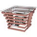 A copper coated stainless steel 6 rung riser with a cooking grate over a metal grill.