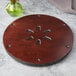 A circular wooden surface with a flower design.
