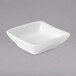 A Villeroy & Boch white square bowl on a gray surface.