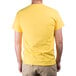 A man wearing a "We Squeeze To Please" large yellow T-shirt.