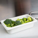 A white Cambro food pan with broccoli inside.