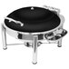 A black round Eastern Tabletop chafing dish with a hinged dome lid on a table.