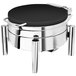 An Eastern Tabletop black coated stainless steel round chafer on a table with a pillar'd stand.