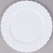 A close up of a white Fineline Flairware plastic plate with a wavy design.