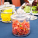 A Thunder Group plastic condiment jar filled with food on a table.