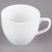A Libbey alpine white porcelain cup with a handle on a gray surface.