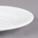 A close-up of a Libbey Alpine White Porcelain saucer with a rim.