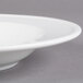 A close-up of a Libbey Alpine White Porcelain Soup Bowl with a rim.