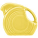 A close-up of a Fiesta Sunflower mini disc creamer pitcher with a handle.
